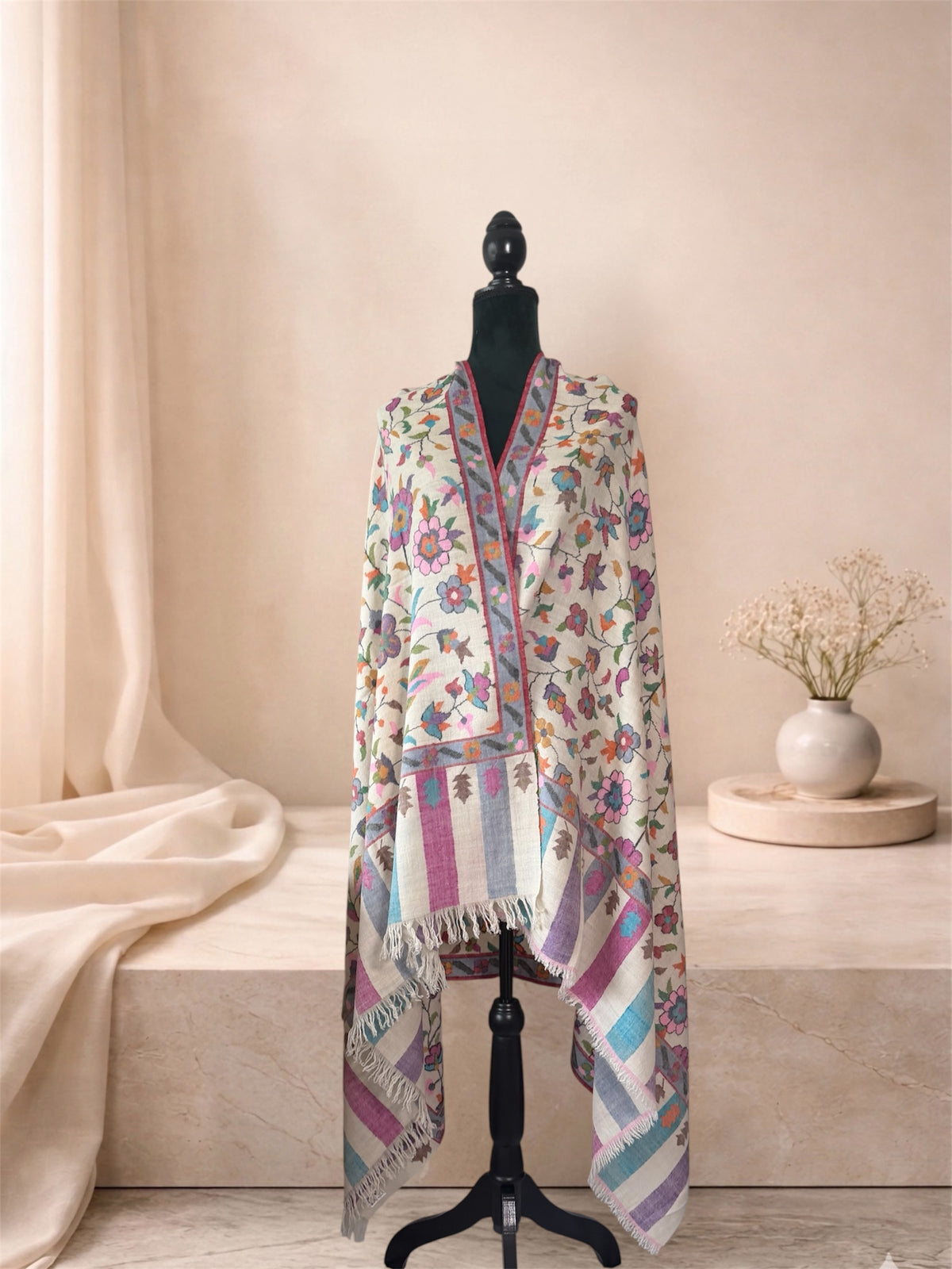 Ivory Kani pashmina shawl with pastel striped ends worn over the shoulders, front view