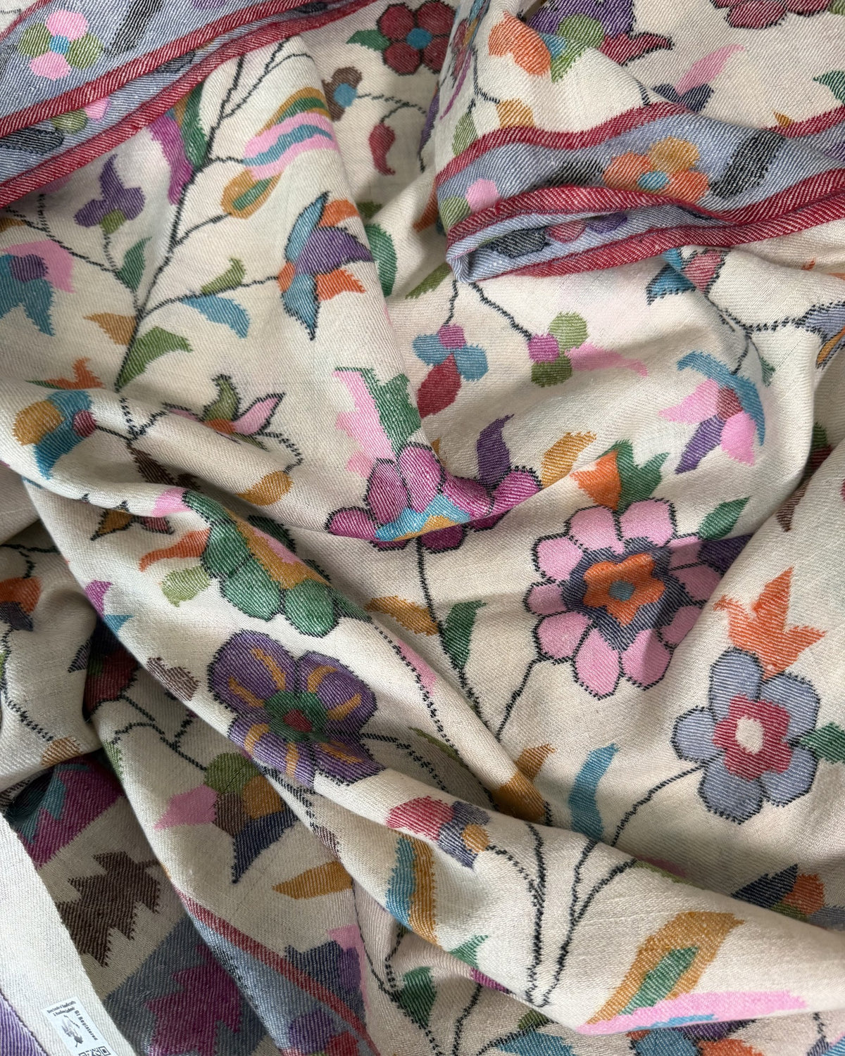 Close-up of pink, lilac and aqua Kani flowers on ivory pashmina